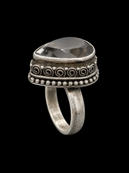 A silver ring with a large, clear CZ stone at its center, set against a plain background.