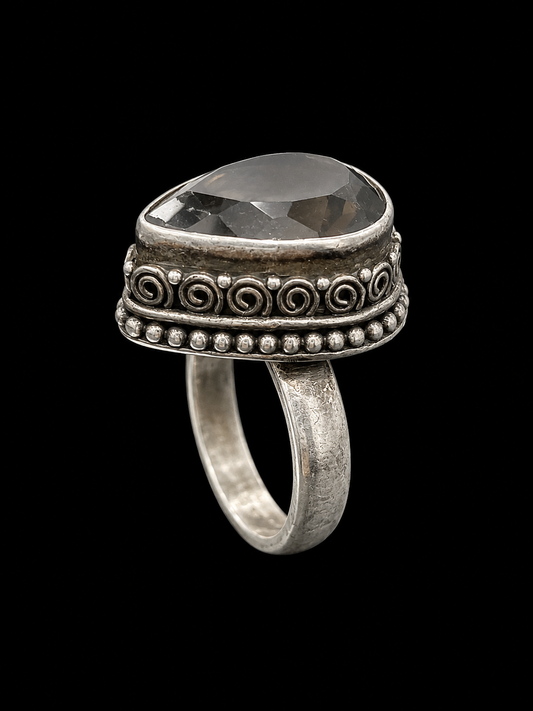 A silver ring with a large, clear CZ stone at its center, set against a plain background.