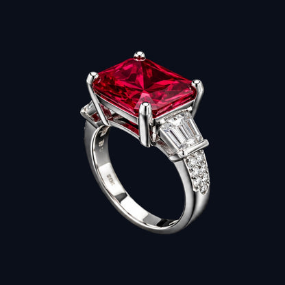 A silver-tone ring with a large ruby stone and smaller CZ stones