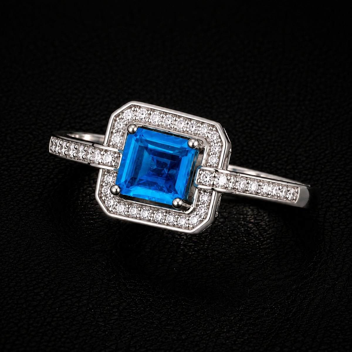 A silver-tone ring with a blue CZ stone in the center, surrounded by clear CZ stones.