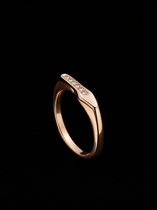 A rose gold ring with clear CZ stones on a black background.