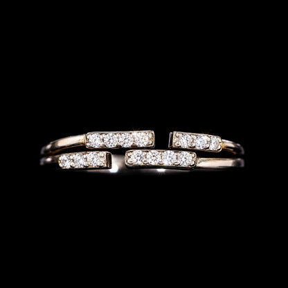 A gold-tone ring with three bars and CZ stones.