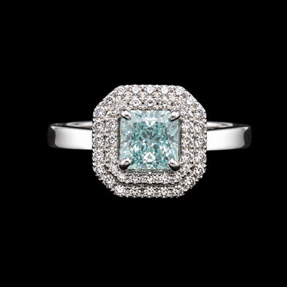 A square halo ring with a large light blue gemstone and clear gemstones in a silver-tone metal