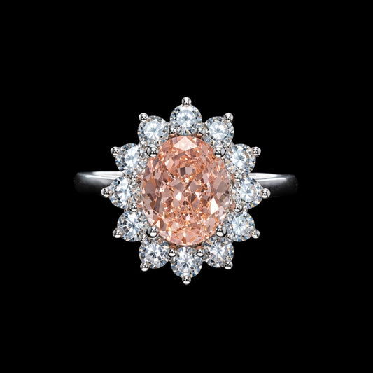 A peach-colored CZ stone ring with clear CZ accents on a silver band.