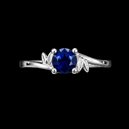 A silver-tone ring with a round-cut blue CZ stone