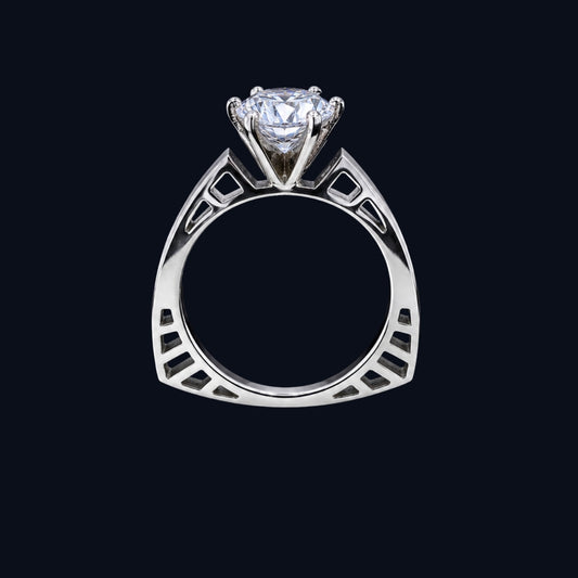 A silver ring with a round-cut CZ stone, set in a geometric design.