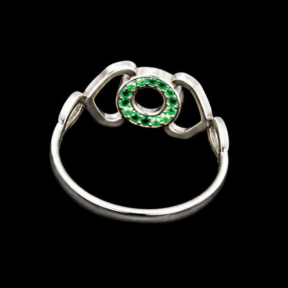 A silver ring with a circular motif and green CZ stones.